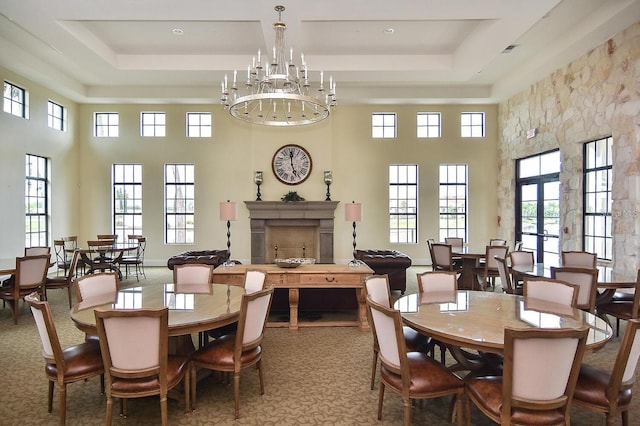 dining area featuring a high ceiling, a tray ceiling, and carpet