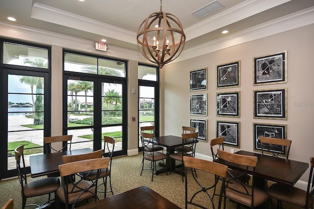 dining room with plenty of natural light, a chandelier, a raised ceiling, and ornamental molding