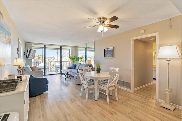 dining space with floor to ceiling windows, ceiling fan, and light hardwood / wood-style flooring