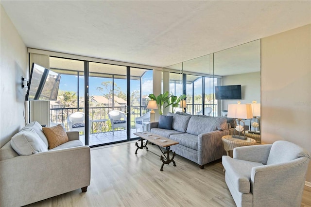 living room featuring expansive windows and light hardwood / wood-style floors