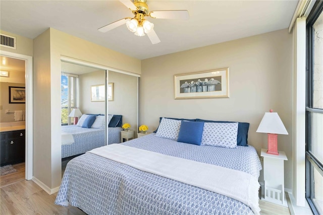 bedroom with ceiling fan, light wood-type flooring, and a closet