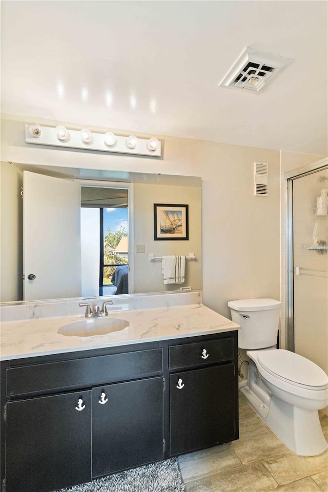 bathroom featuring vanity, toilet, and an enclosed shower