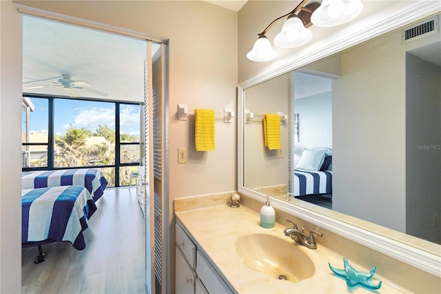 bathroom with wood-type flooring, vanity, and ceiling fan