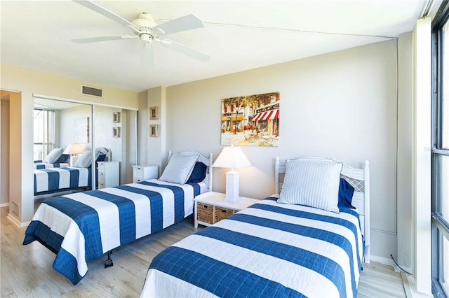 bedroom featuring hardwood / wood-style flooring, ceiling fan, and a closet