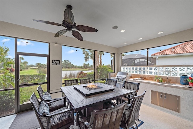 sunroom with ceiling fan and sink