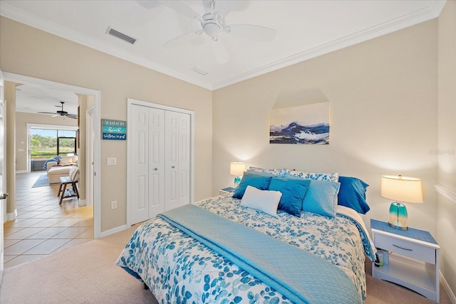 carpeted bedroom featuring ceiling fan, a closet, and crown molding