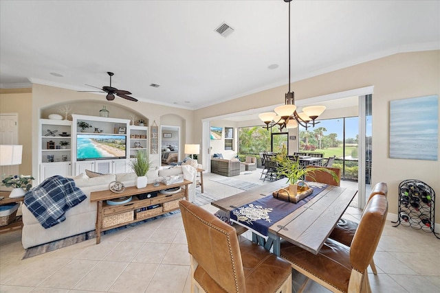 tiled dining room with built in shelves, ceiling fan with notable chandelier, and crown molding