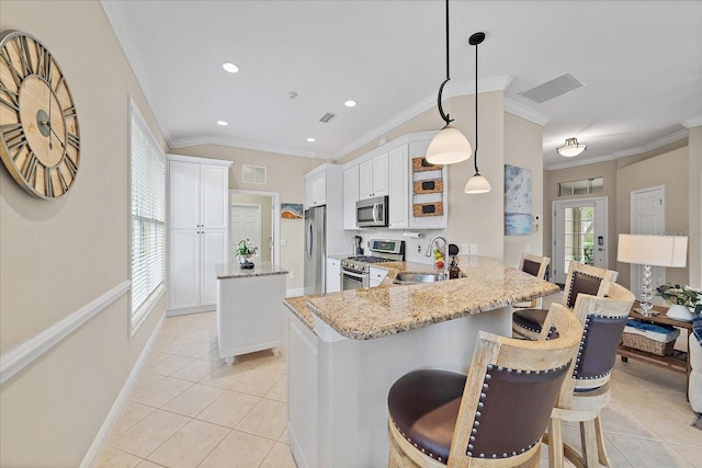 kitchen with visible vents, light stone counters, a peninsula, stainless steel appliances, and a sink