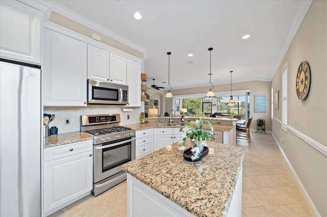 kitchen featuring backsplash, crown molding, a peninsula, light tile patterned flooring, and stainless steel appliances