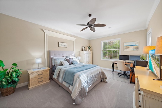 bedroom featuring baseboards, light carpet, a ceiling fan, and crown molding