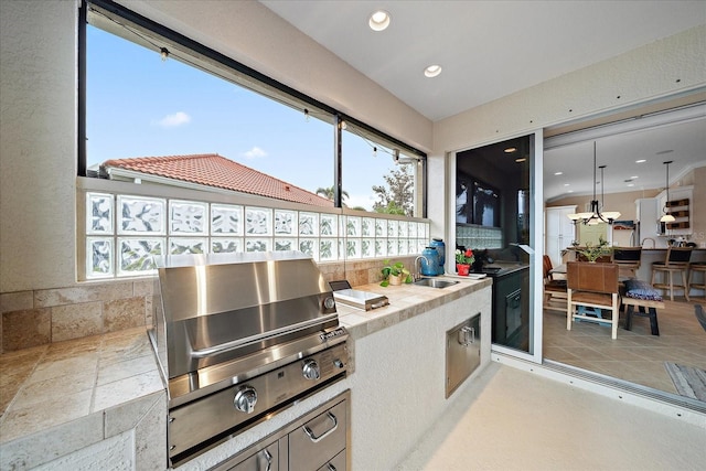 interior space featuring a wealth of natural light, recessed lighting, light countertops, and a sink