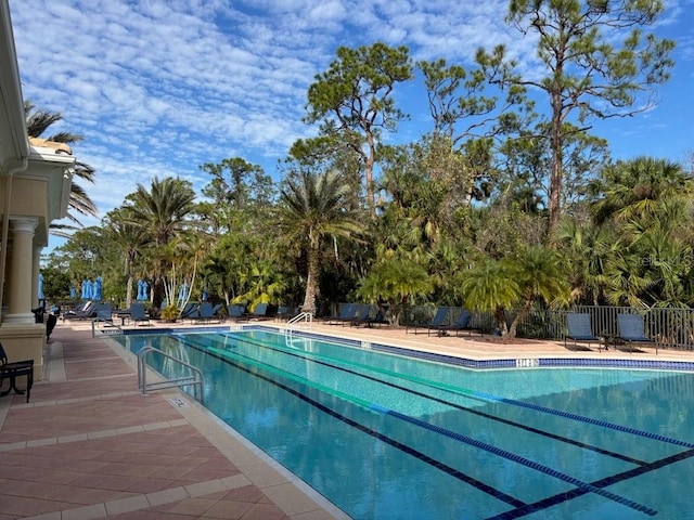 pool with a patio and fence