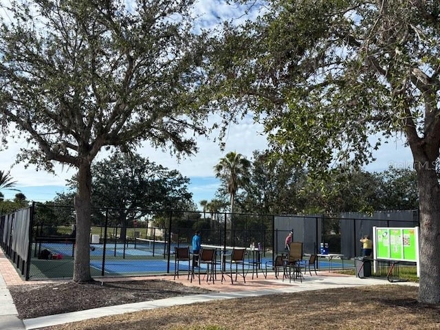 exterior space featuring a tennis court and fence