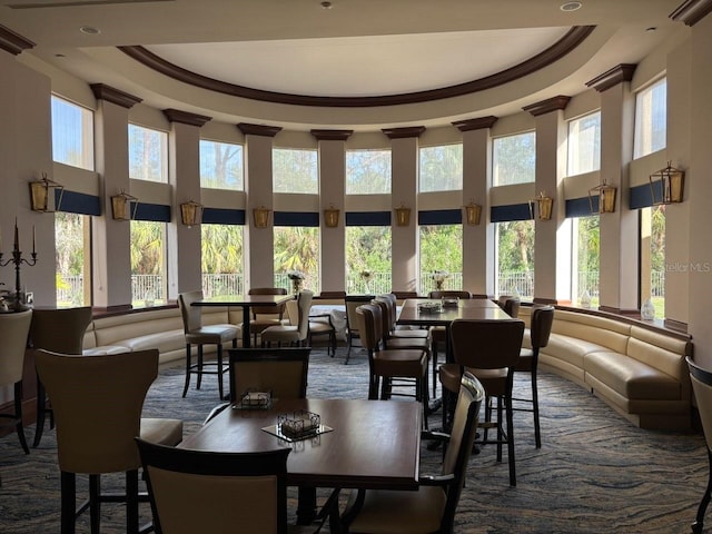 dining space with a raised ceiling and a towering ceiling