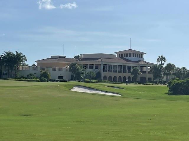 surrounding community with view of golf course and a lawn