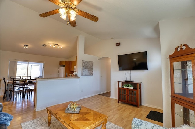 living room featuring ceiling fan, light hardwood / wood-style floors, and vaulted ceiling