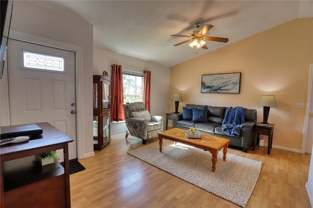 living room with ceiling fan, light wood-type flooring, and vaulted ceiling