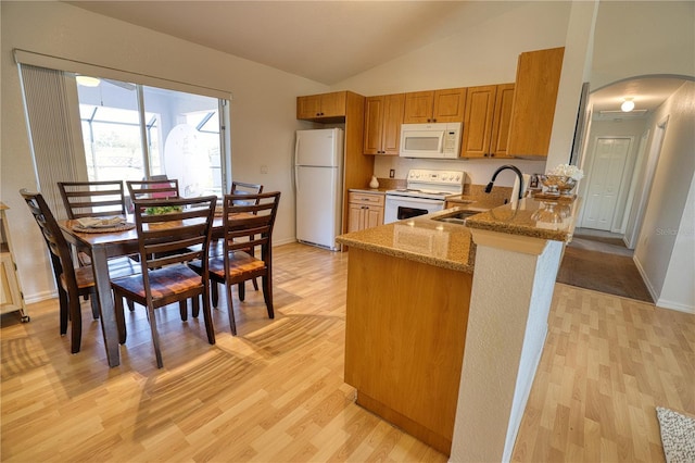 kitchen featuring light hardwood / wood-style floors, light stone countertops, white appliances, and sink