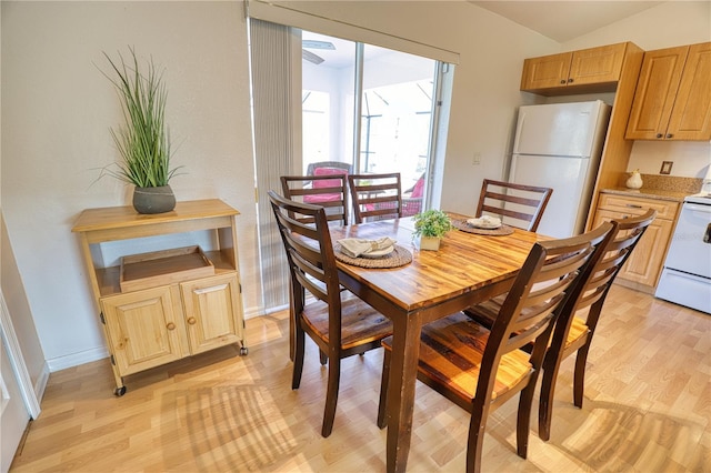 dining area with light hardwood / wood-style floors and lofted ceiling