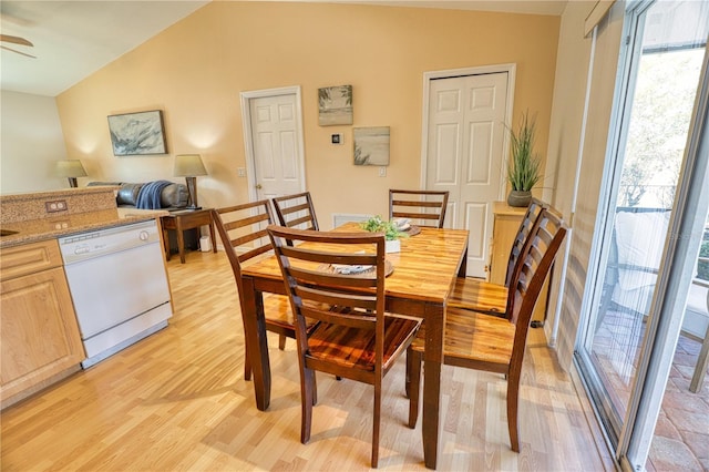 dining area with ceiling fan, light hardwood / wood-style floors, and vaulted ceiling