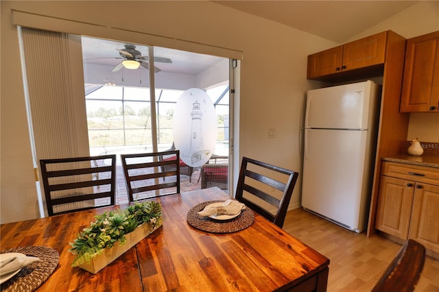 dining space with ceiling fan, light hardwood / wood-style floors, and lofted ceiling