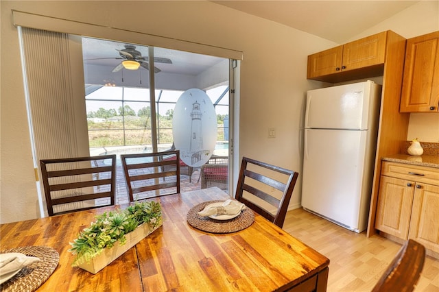 dining space featuring vaulted ceiling, light hardwood / wood-style flooring, and ceiling fan