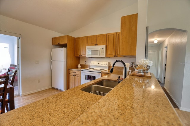 kitchen featuring white appliances, high vaulted ceiling, sink, light wood-type flooring, and light stone counters