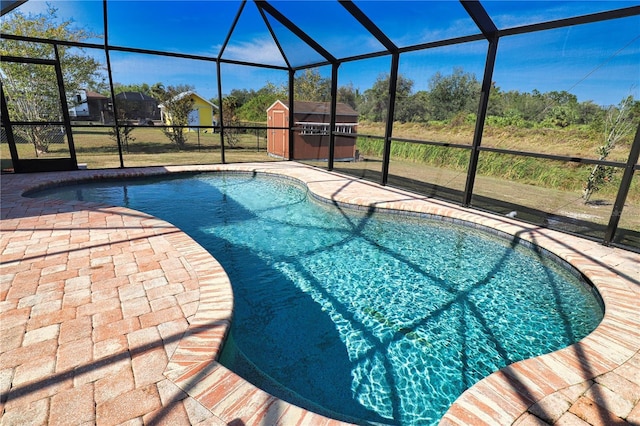 view of pool featuring a patio, a storage unit, and a lanai