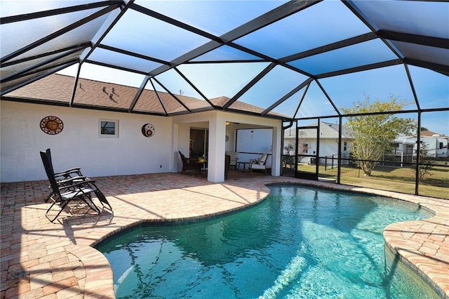 view of pool featuring glass enclosure and a patio