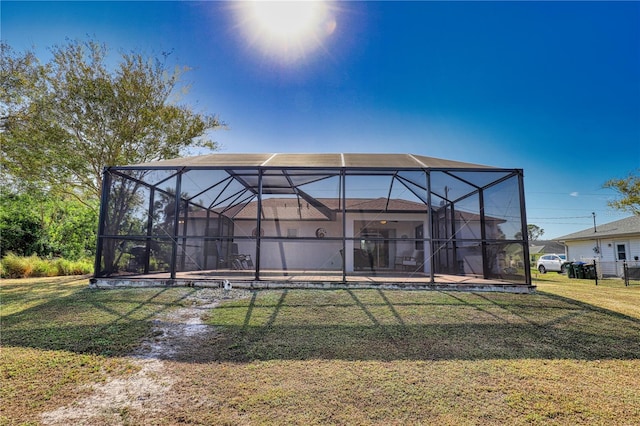 rear view of house featuring a lanai and a lawn