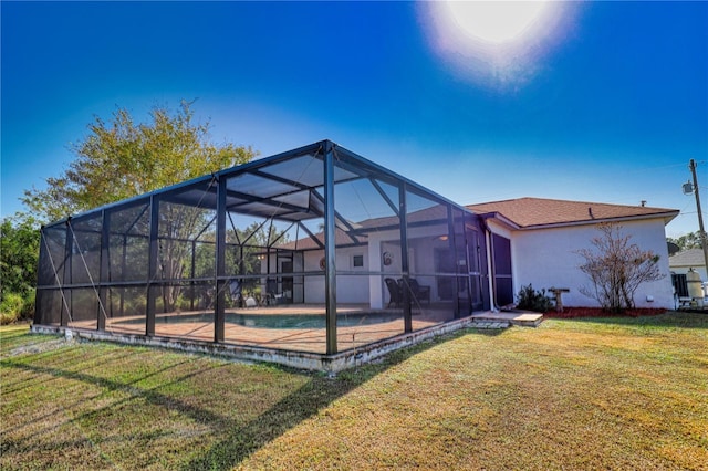 back of house featuring a lanai and a lawn