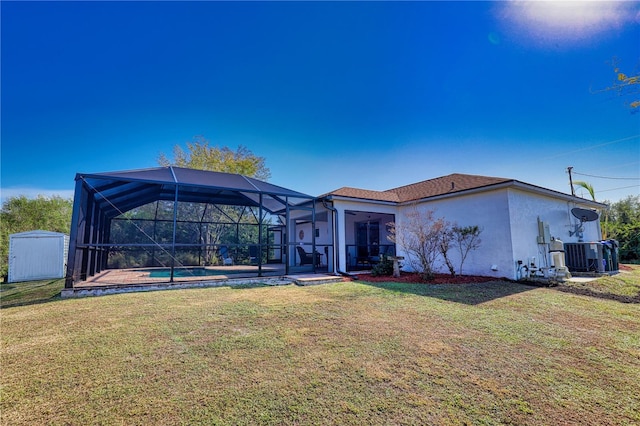 back of house featuring a lawn, glass enclosure, central air condition unit, and a swimming pool