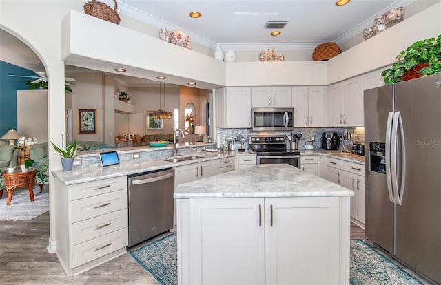 kitchen featuring pendant lighting, white cabinetry, kitchen peninsula, and stainless steel appliances