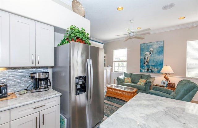 kitchen featuring decorative backsplash, stainless steel refrigerator with ice dispenser, white cabinetry, and light stone counters