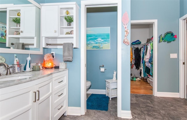 interior space featuring light stone counters, white cabinetry, and sink