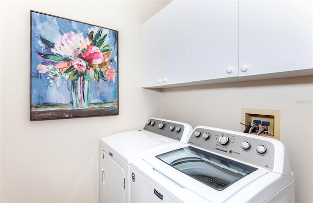 laundry area featuring washer and clothes dryer and cabinets