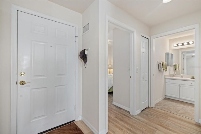 foyer featuring sink and light wood-type flooring