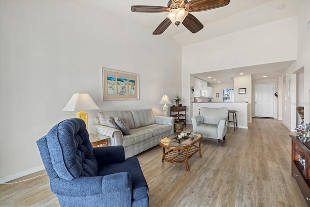 living room featuring high vaulted ceiling, ceiling fan, and light hardwood / wood-style flooring