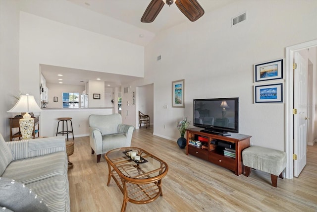 living room with light hardwood / wood-style floors, ceiling fan, and vaulted ceiling