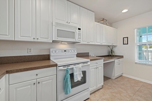 kitchen with white appliances, light tile patterned floors, and white cabinetry