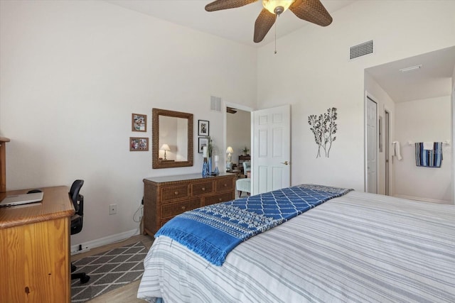 bedroom with ceiling fan, a closet, and a towering ceiling