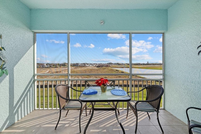 sunroom / solarium featuring a water view