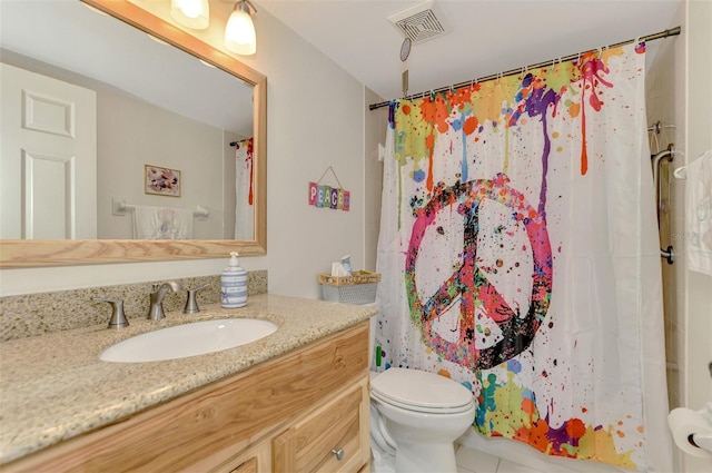 bathroom with tile patterned flooring, vanity, toilet, and walk in shower