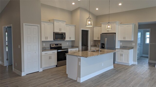 14464 Fort Myers Ave, Port Charlotte, FL 33981 - kitchen featuring appliances with stainless steel finishes, a sink, baseboards, high vaulted ceiling, and white cabinets