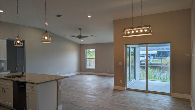 14464 Fort Myers Ave, Port Charlotte, FL 33981 - kitchen featuring a sink, black dishwasher, baseboards, light wood finished floors, and white cabinetry