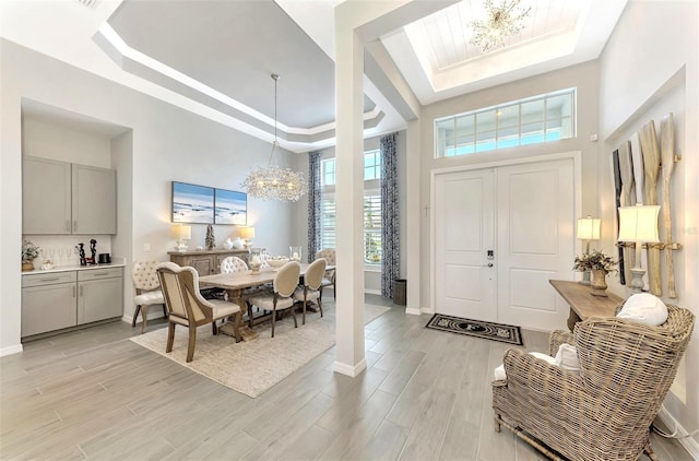 entrance foyer with a chandelier and a tray ceiling