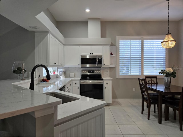 kitchen featuring pendant lighting, light stone counters, white cabinetry, and stainless steel appliances