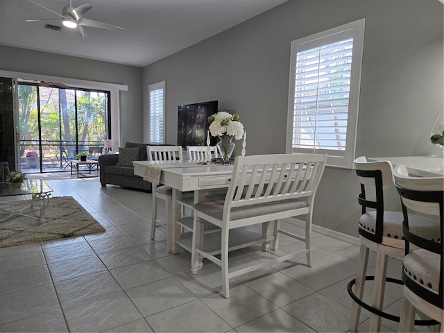 tiled dining space with ceiling fan