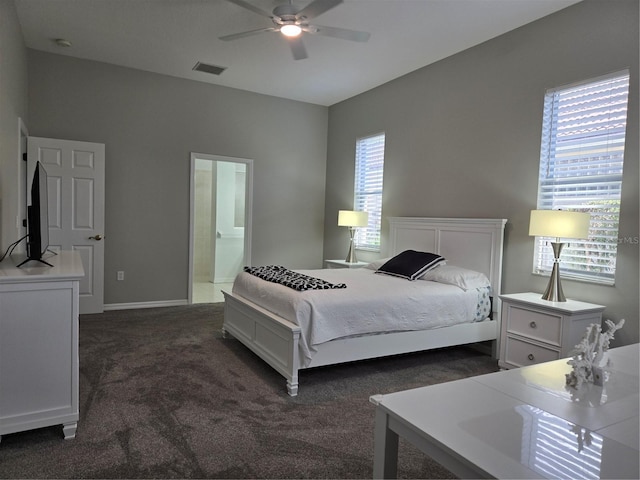 carpeted bedroom with multiple windows, ceiling fan, and ensuite bathroom