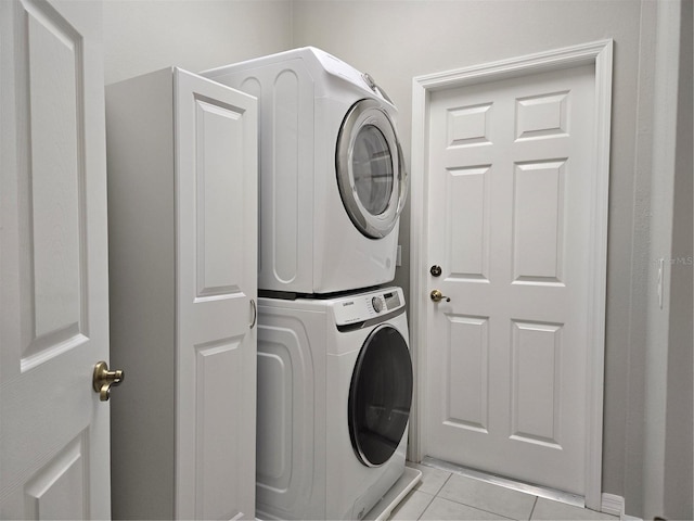 washroom with light tile patterned floors and stacked washer / drying machine